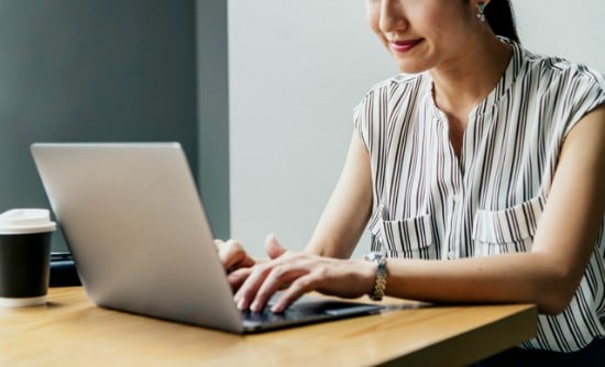 Woman sitting at laptop - real estate market report looking concept