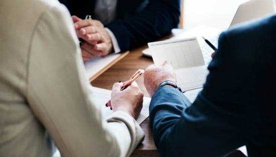 bankers sitting at table with pre-approval loan paperwork