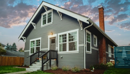 house with grey siding against blue sky with clouds