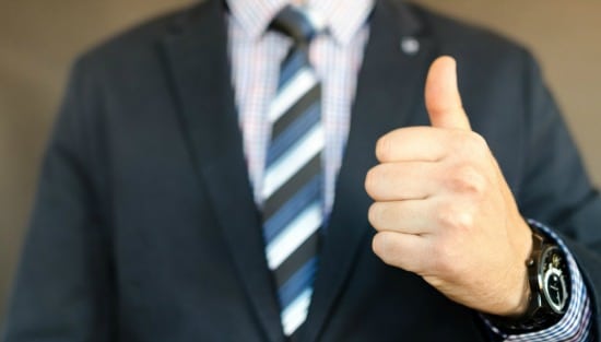 man in suit holding thumb up