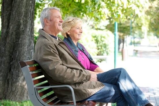 senior couple sitting on a park bench