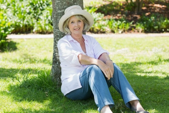 senior woman sitting under tree