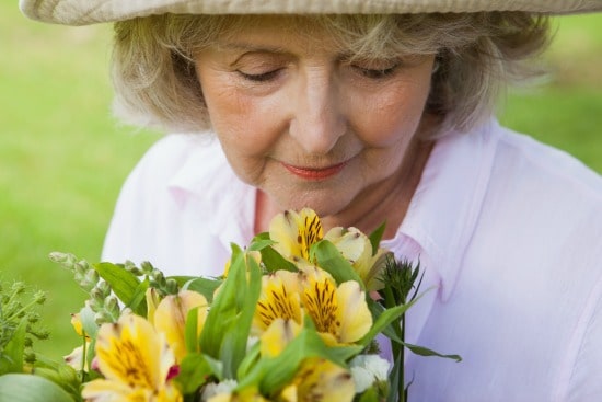 senior woman smelling flowers